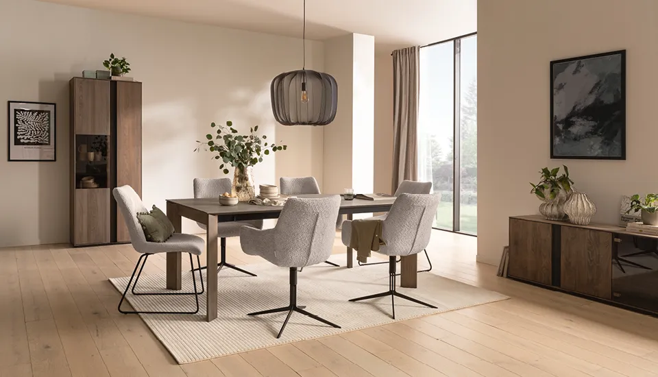 Helles Esszimmer mit großem Holztisch, grauen Polsterstühlen und stilvoller Pendelleuchte, kombiniert mit Holzvitrine und Sideboard, schafft ein modernes und gemütliches Wohnambiente mit natürlichem Design.